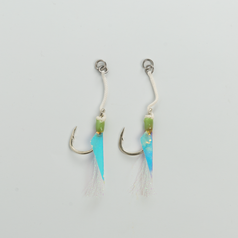 Two fishing lures with blue and green blades on a light gray background